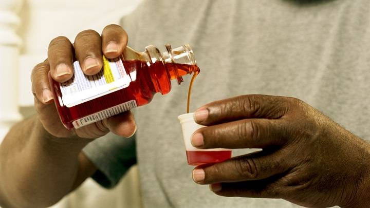 closeup man pouring cough medicine 200214551 001